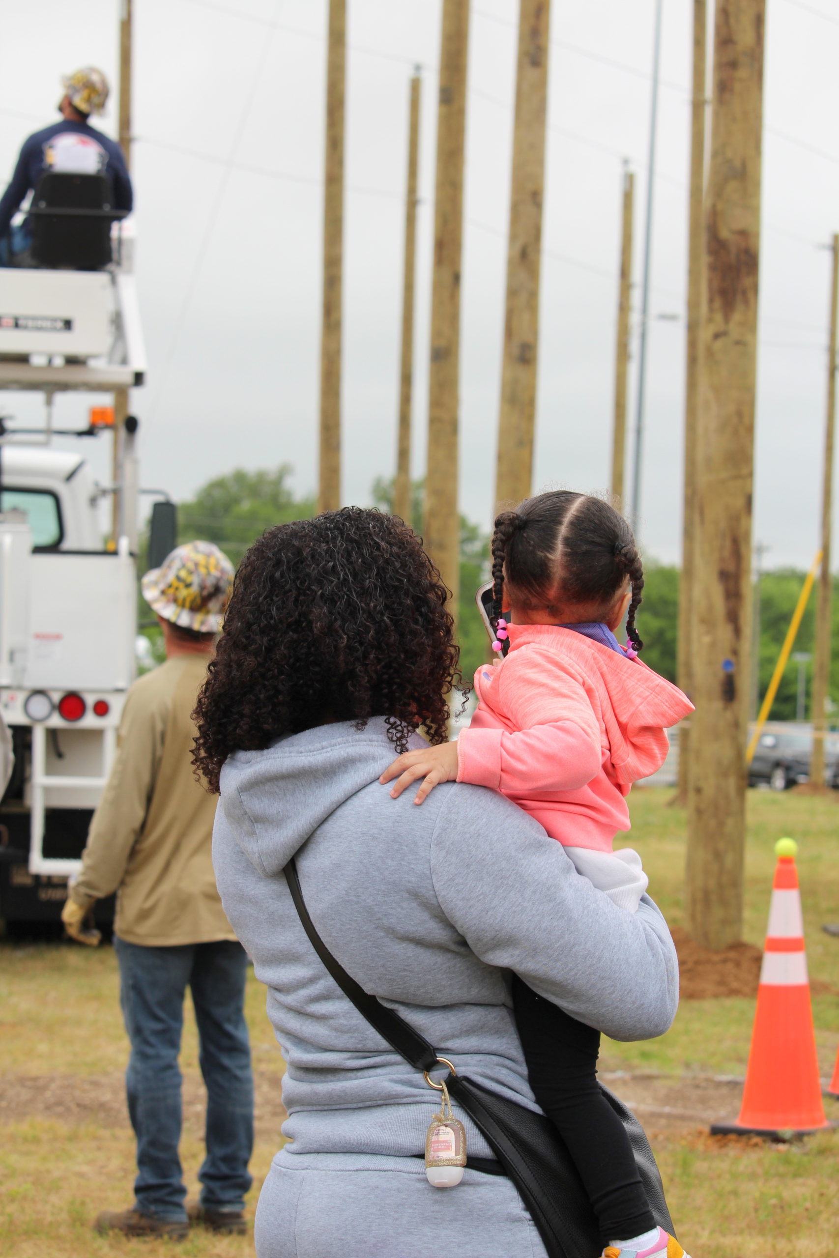 Jasmine Forward watches along with her young daughter as her husband, REC lineworker Tony Forward, competes in the Equipment Operator’s Rodeo.